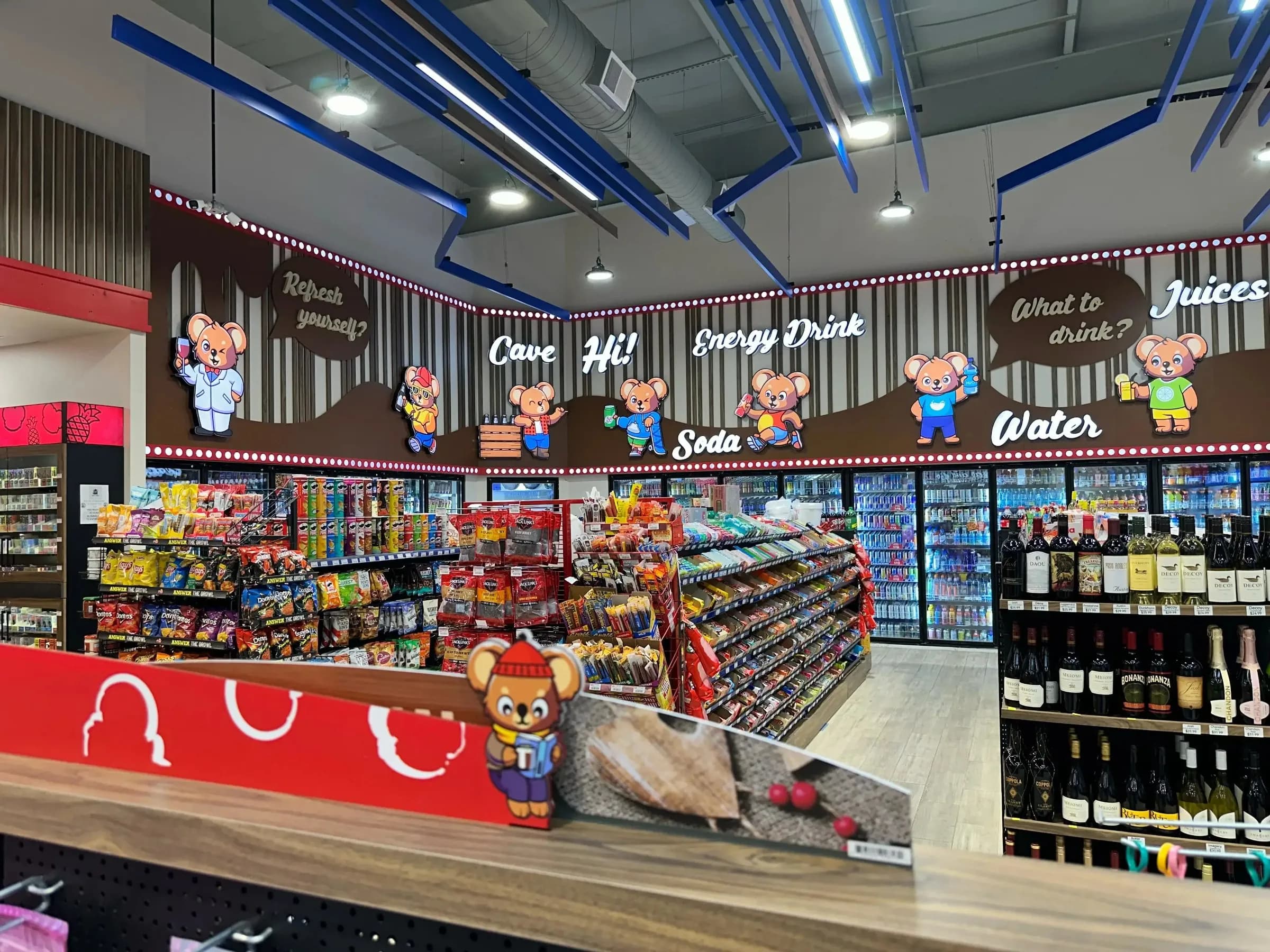 Category signage above the beverage coolers and wine shelving at Teddy's Market convenience store, Georgia